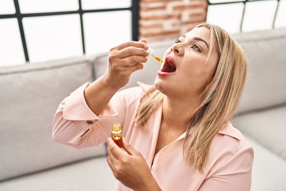 Lady Using Dropper Bottle In Mouth